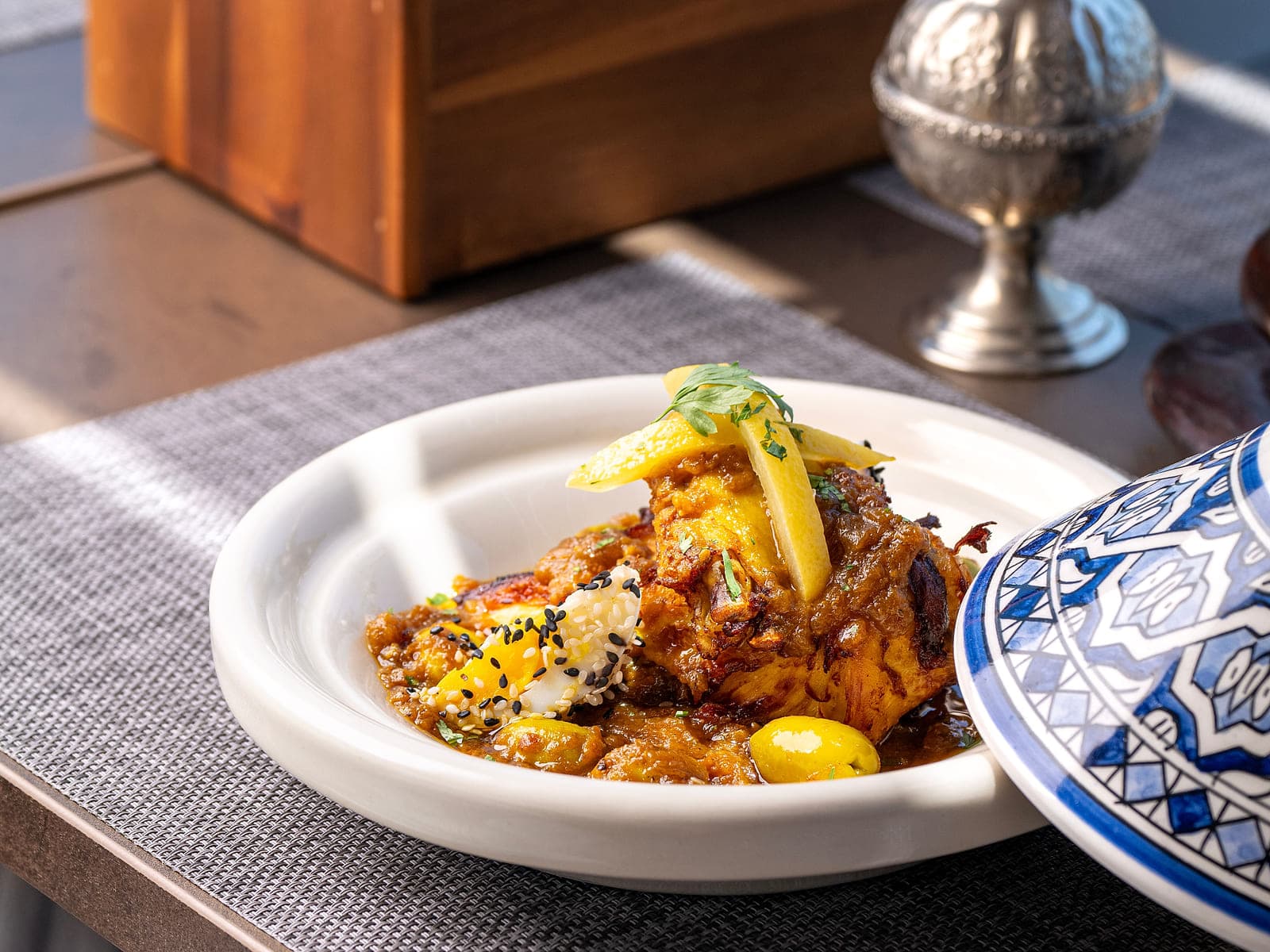 Moroccan chicken tagine with preserved lemon slices and green olives in a clay dish